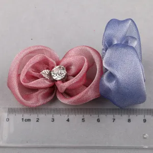Handgemachte Organza Blüte Kleiderzubehör Detailaufnahme mit Strassstein und Blattanhänger.