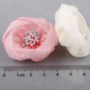 Detailaufnahme handgefertigter Organza-Stoffblumen-Accessoires mit feinen Blütenblattstrukturen.