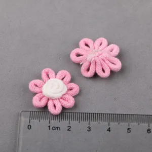 Closeup of handmade pink fabric flower accessories DIY craft detail view scale with ruler