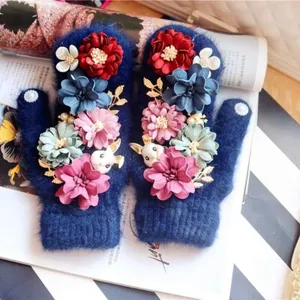 Handgefertigte flauschige Winterhandschuhe mit niedlichem Stoffhasen und bunten Stoffblumen.
