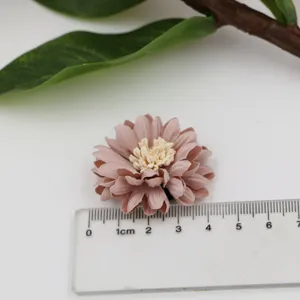 Nahaufnahme der handgefertigten Mikrofaser Blume DIY Zubehör in zartem Rosa mit Crememitte.