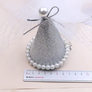 Close-up detail of children princess cone hair clip with pearl trim, mesh veil and silver bow.