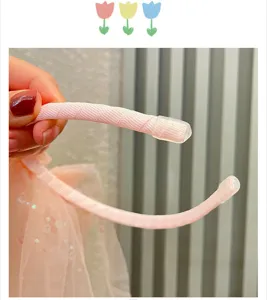 Détail de serre-tête fille rose, texture douce et embouts de protection pour fête.