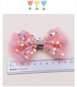Rosa Pailletten Netz Schleife Haarspange mit Silberkrone Detail, gezeigt mit einem Lineal.