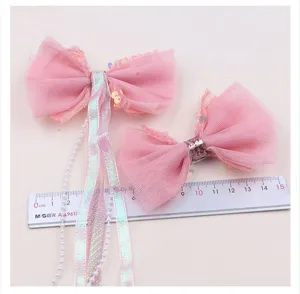 Detailaufnahme der rosa Pailletten Tüll Schleife Haarspange mit Bändern und Perlen.
