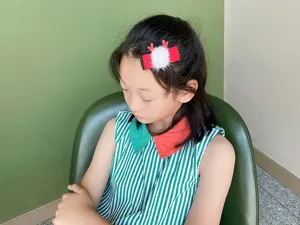 Nahaufnahme eines Kindes mit niedlicher Weihnachts-Renntier-Haarspange und Pompon.