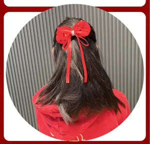 Rote Pailletten Schleife Haarklammer Detail zeigt den Trageeffekt und elegantes langes Band.