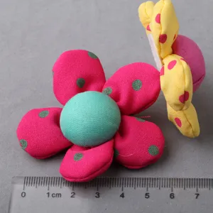 Closeup of handmade fabric flower accessories with polka dots, colorful floral decor.