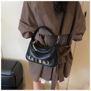 Detailaufnahme einer stilvollen schwarzen Schultertasche mit bunten Kristall-Strasssteinen.
