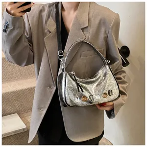 Silberne metallische Schultertasche im Detail mit Kristallen, modisches Y2K Design.