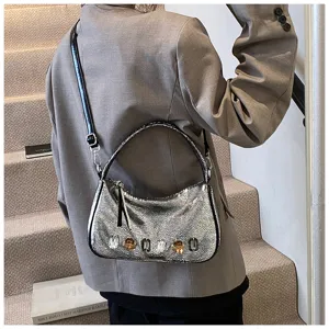 Detailansicht einer schicken silbernen Metallic-Umhängetasche mit Kristallen für den Alltag.