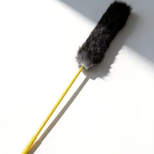 Primer plano detalle de la cabeza de juguete para gatos de pelo negro y varilla amarilla.