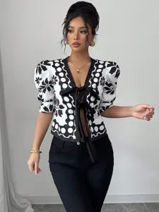 Black and white patterned puff sleeve tie-front blouse detail showing elegant summer style.