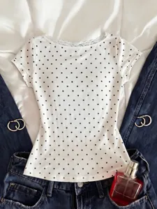 Detailed view of a chic white polka dot short sleeve top with delicate V-neck lace trim.