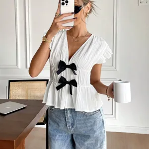 Schicke weiße Sommerbluse mit V-Ausschnitt, kurzen Ärmeln und eleganten schwarzen Schleifen.