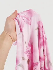 Close-up detail of lightweight pink floral mesh fabric, soft texture for women apparel.