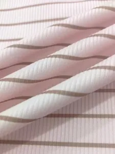 Primo piano del tessuto in maglia a costine a righe rosa e marrone che mostra la consistenza.