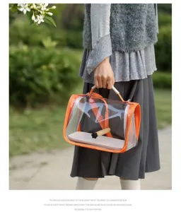 Detailed view of the clear portable bird travel bag featuring transparent pvc and wooden perch.