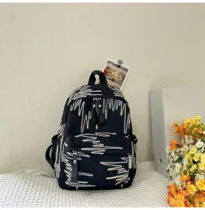 Schicker schwarzer Mini-Rucksack für Damen mit buntem abstrakten Stickmuster Design.