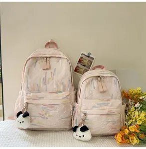 Detailansicht des niedlichen rosa Rucksacks mit bunter Stickerei und Pluesch Anhaenger.