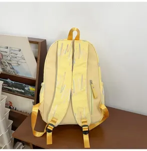 Gelber Rucksack Detail mit bunten bestickten Gurten und praktischem Reißverschlusstaschen-Design.