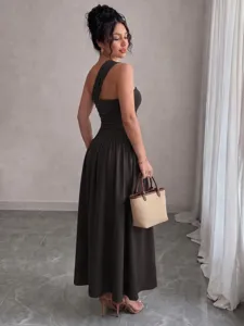 Detailed shot of a stylish one-shoulder sleeveless pleated maxi dress worn by a model.