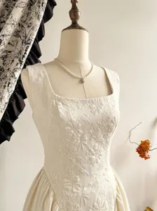 Close-up detail of the white floral embossed jacquard fabric, elegant square neck sleeveless dress.
