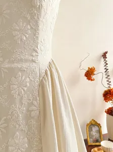 French elegant embossed sleeveless midi dress detail view, chic floral textured bodice.