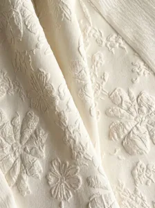 Close-up of elegant embossed floral fabric detail, highlighting exquisite texture and design.