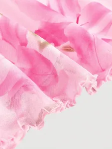 Close-up detail of pink floral mesh dress fabric featuring delicate lettuce edge trim.