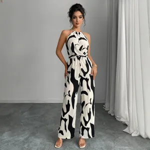 Chic black white halter jumpsuit featuring abstract milk print and tie waist for summer fashion.
