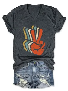 Dark grey V-neck short sleeve t-shirt with retro peace sign graphic and blue denim shorts.