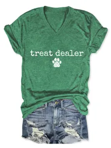 Gros plan sur le t-shirt vert à col en V avec texte treat dealer et empreinte de patte.