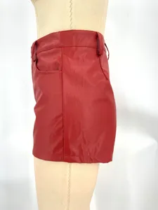 Close-up detail shot of red PU leather shorts showing high waist and side pocket design.