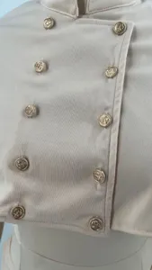 Nahaufnahme des eleganten beigen zweireihigen Kleidungsdetails mit goldenen Anker-Knöpfen.