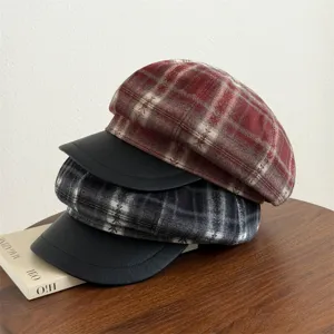 Detail view of retro plaid newsboy hats with leather brim, stylish autumn winter headwear.