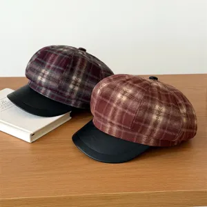 Detail view of Korean style plaid newsboy caps with black leather brims for autumn winter.