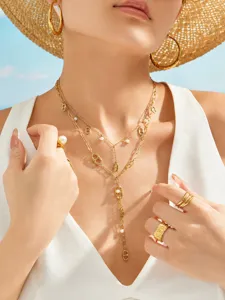 Close-up of 18k gold stainless steel multi-layer Y necklace with pearls and matching earrings.