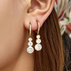 Detailed close-up view of triple graduated cubic zirconia drop earrings in gold plating.