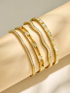 Close-up detail of multi-layer gold metal zircon bracelets, niche European American style.