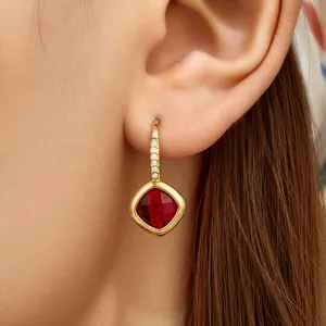 Elegantly designed square red glass crystal pendant earrings with sparkling zirconia on gold tone.