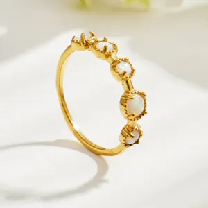 Delicate gold ring featuring gleaming white stones in a minimalist design detail.