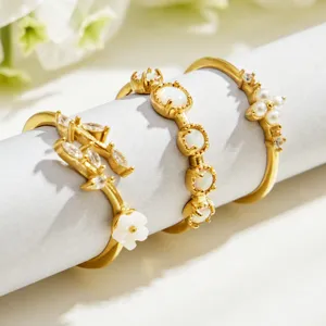 Minimalist gold stainless steel ring three-piece set with zircon pearls and floral details for daily wear.