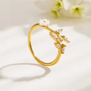 Exquisite close-up of a minimalist gold floral ring with sparkling cubic zirconia leaves.