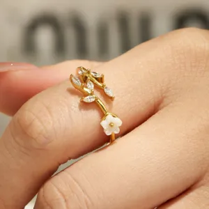 Elegant gold floral zircon ring featuring delicate leaf and white flower design for women.