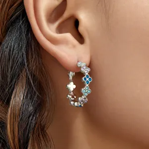 Primer plano detallado de los hermosos pendientes de aro con diseño de trébol de circonita.
