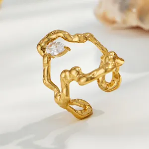Close-up of irregular gold-plated stainless steel ring with sparkling zircon stone minimalist design