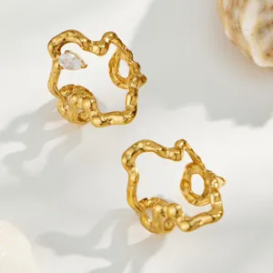 Close-up detail of irregular gold plated stainless steel geometric rings with sparkling zircon.