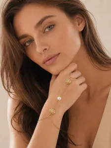 Exquisito detalle de pulsera mano concha perla, elegante joya de acero titanio bañado en oro.