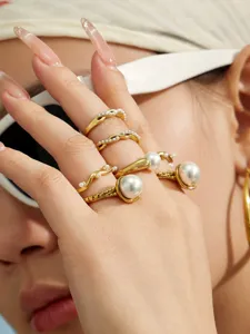 Nahaufnahme von unregelmässigen wellenförmigen Gold-Perlenringen, sehr elegant und chic.